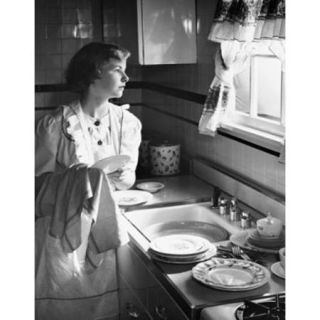 Young woman washing dishes and looking out window Poster Print (18 x 24)